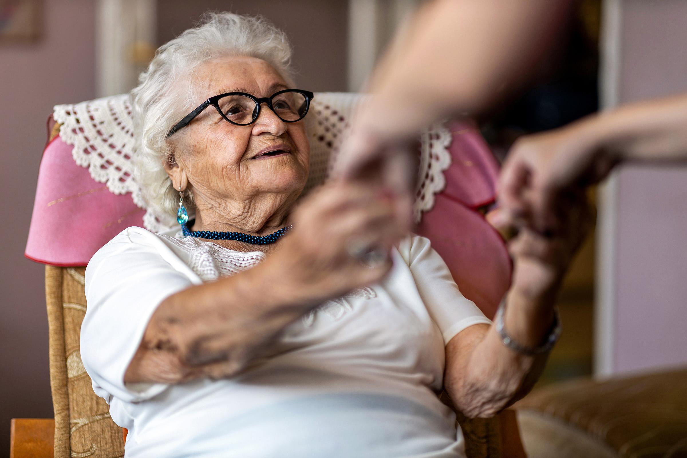 Elderly women being helped up from her seat